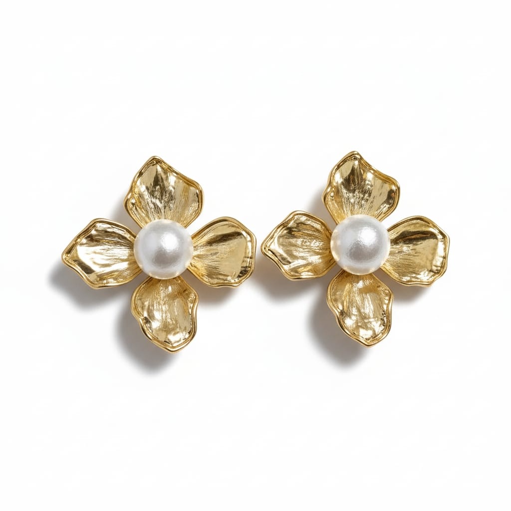 A pair of gold flower-shaped stud earrings with textured petals and a central white pearl, shown on a clean white background.