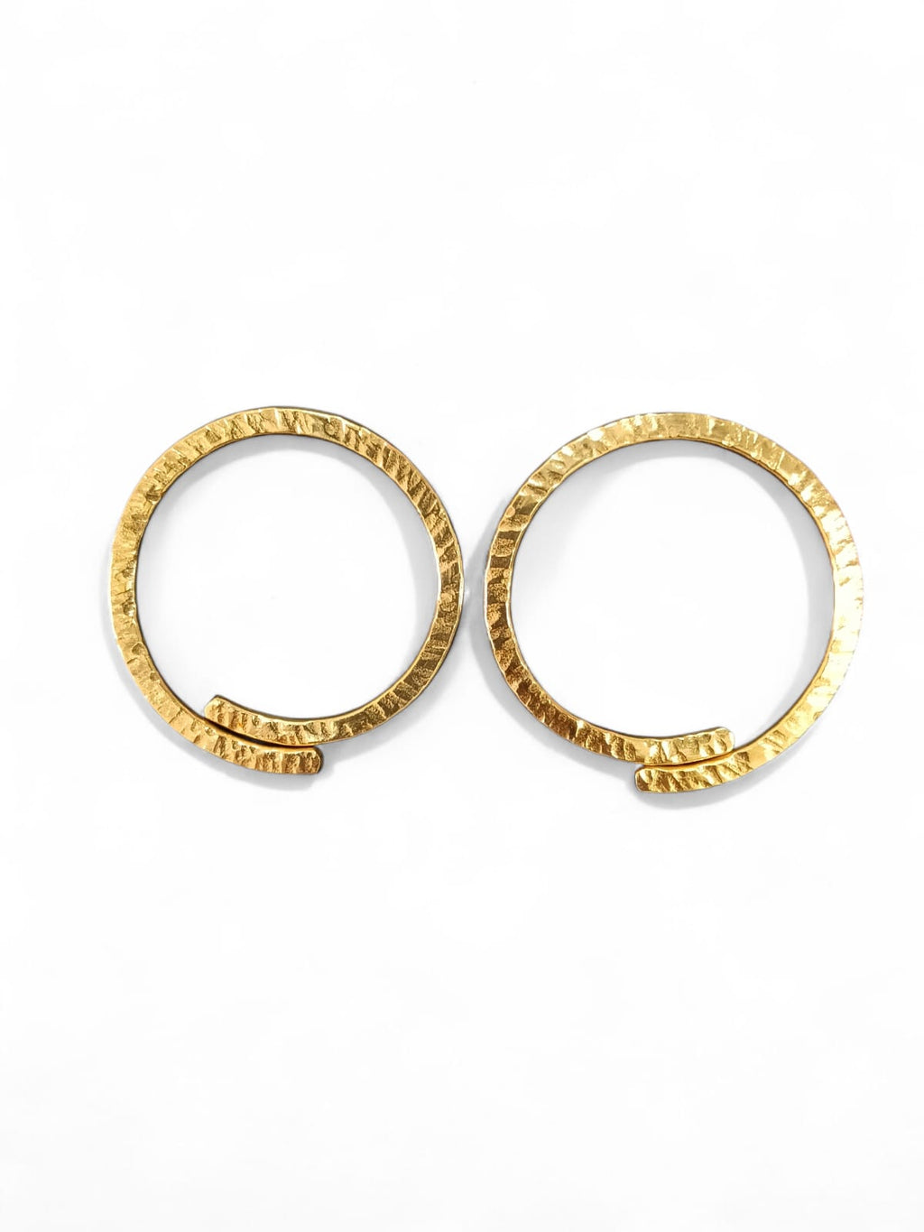 A pair of textured gold hoop earrings on a clean white background.