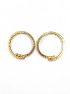 A pair of textured gold hoop earrings on a clean white background.