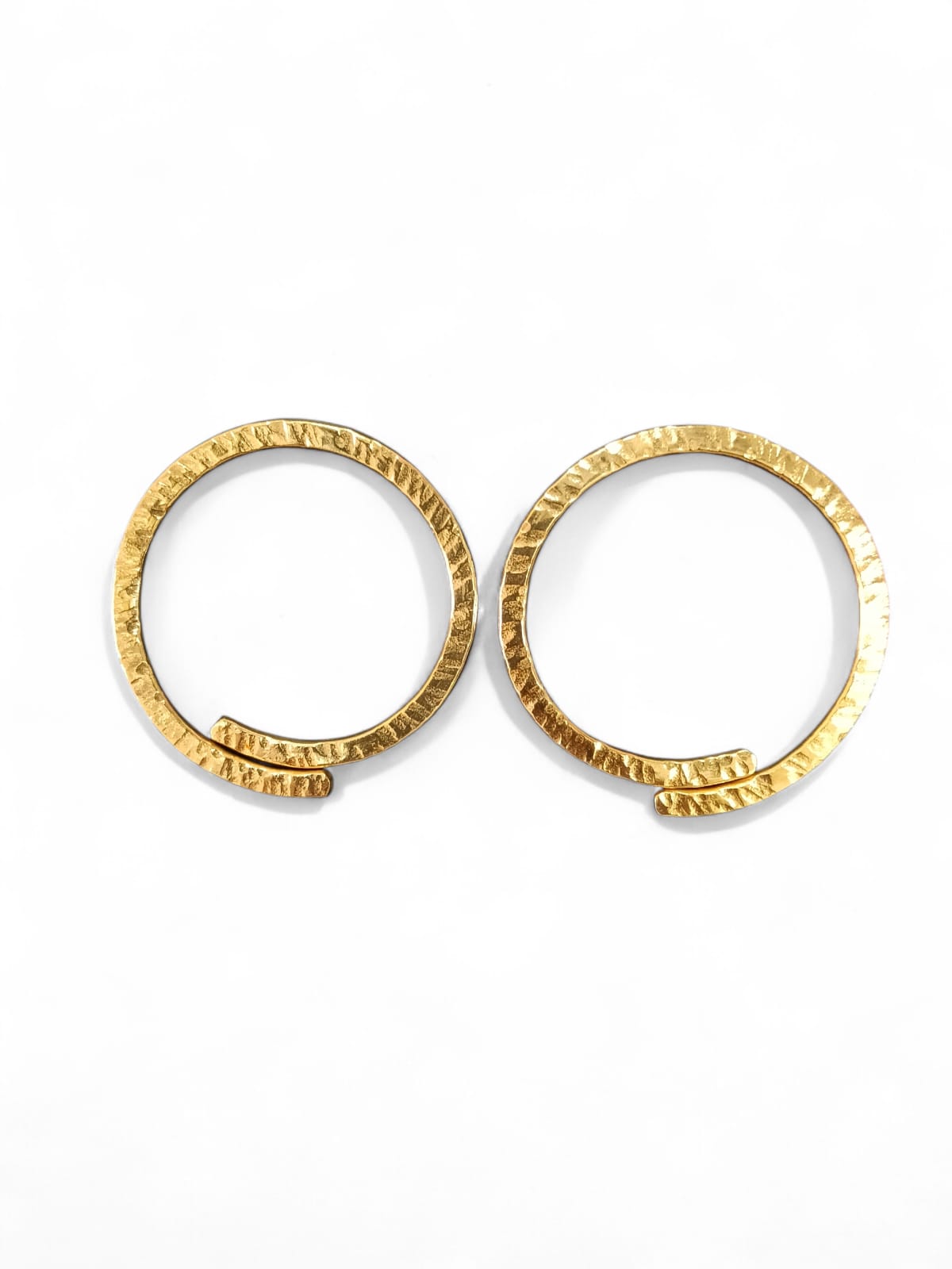 A pair of textured gold hoop earrings on a clean white background.