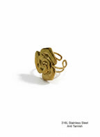 A gold-colored stainless steel ring with a sculptural, abstract flower-like top and a thin wire band, shown on a plain white background with a small text overlay in the bottom right corner.
Grishita Jewellery