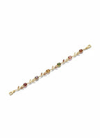 A delicate gold bracelet featuring a vine and leaf motif with small, colorful gemstone accents in red, pink, green, and purple, displayed on a clean white background.
Grishita Jewellery