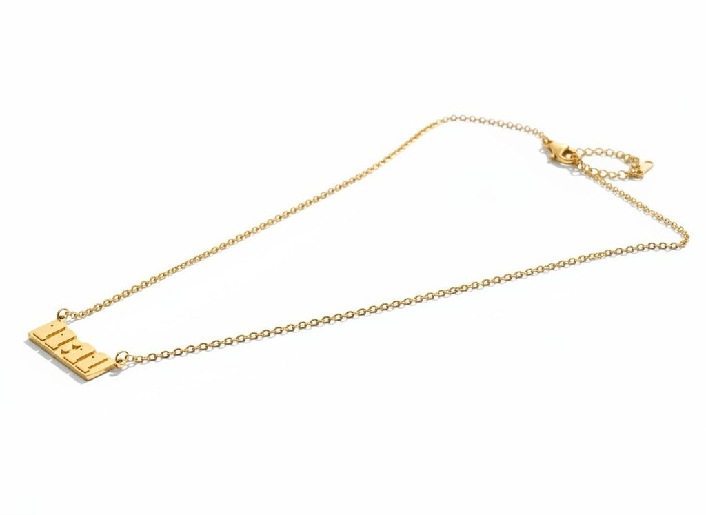 A delicate gold chain necklace featuring a rectangular nameplate pendant engraved with the name 'ELI', displayed on a clean white background.
Grishita Jewellery