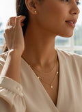 A woman in a cream satin blouse is shown in a bright home office setting, with a text overlay reading '316L Stainless Steel. Anti-Tarnish, Affordable Luxury'.